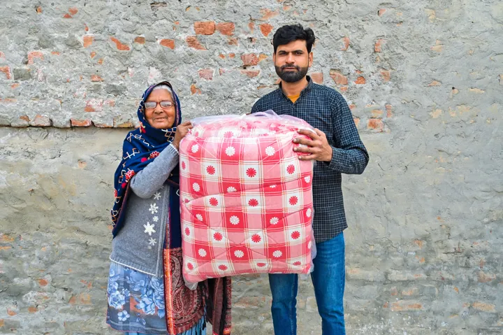 A woman receiving a colourful winter blanket