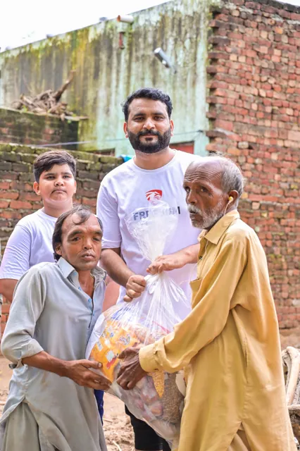 A community member and children beside a water pump