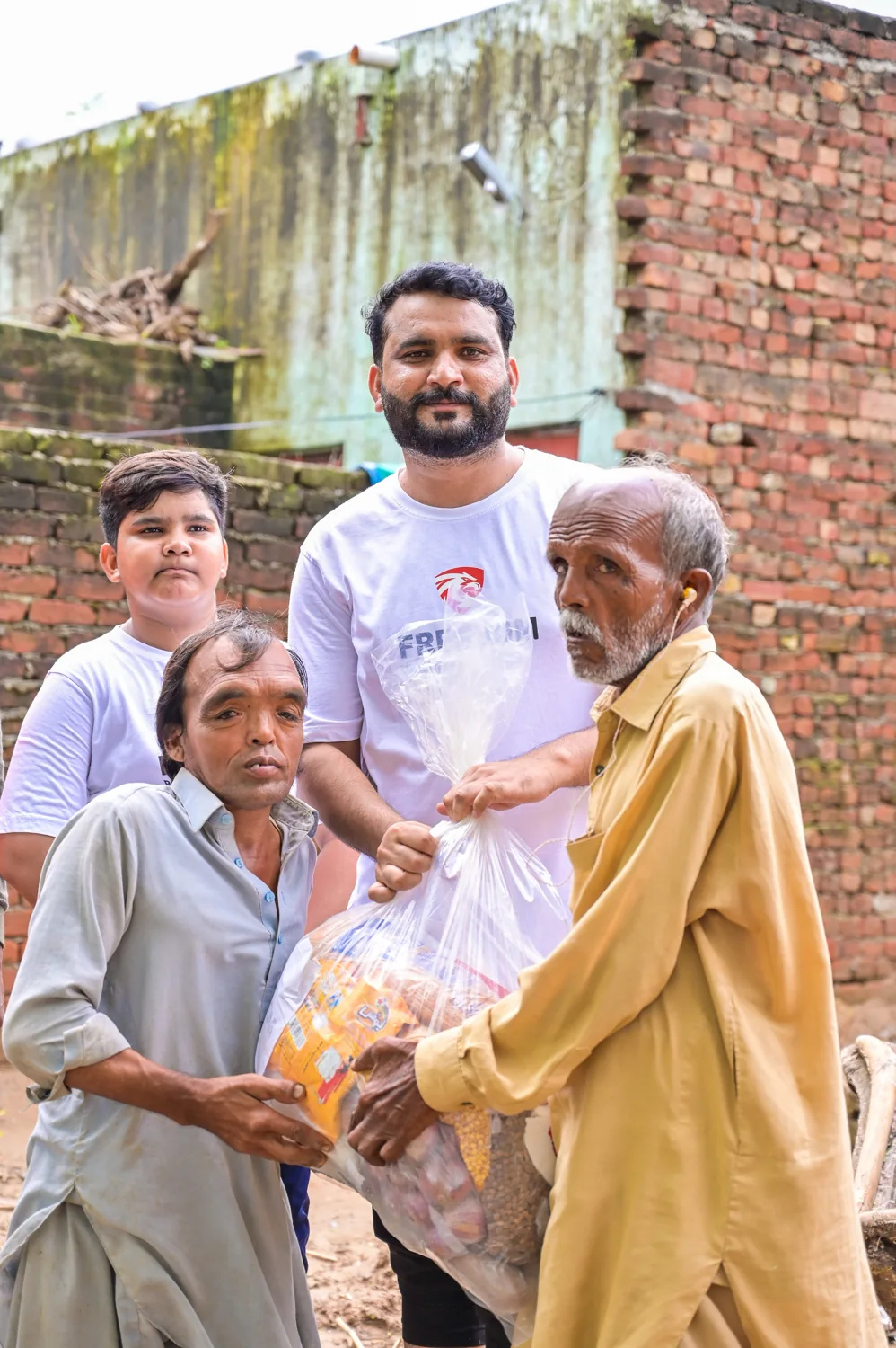 Children and a community member beside a water pump